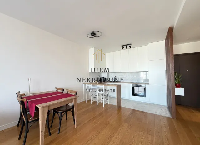 Modern kitchen with dining area and white cabinets.