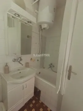 Smaller bathroom with a bathtub, washbasin, and mirror. - image 10