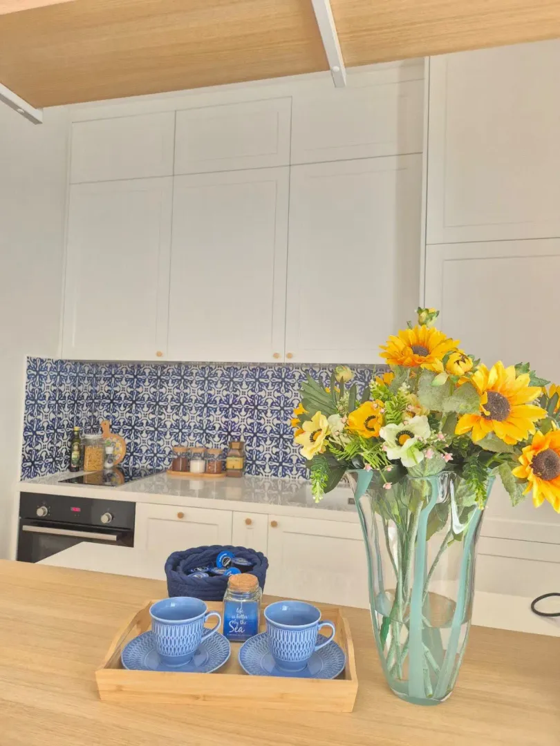 Modern white kitchen with decorative tiles and a countertop.