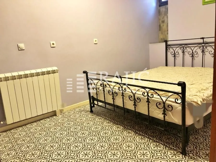 Spavaća soba sa metalnim krevetom i radijatorom.