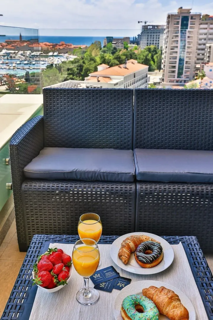 Furnished terrace with seating furniture and a view of the city and sea.