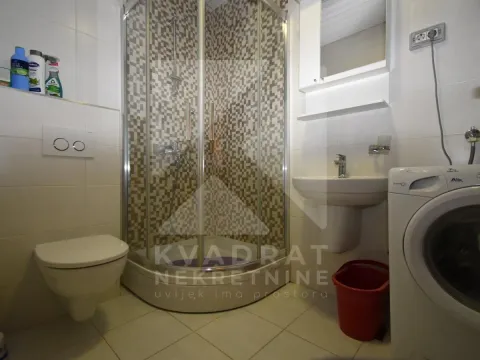 Kupatilo opremljeno tuš kabinom, umivaonikom, toaletom i veš mašinom. - image 9
