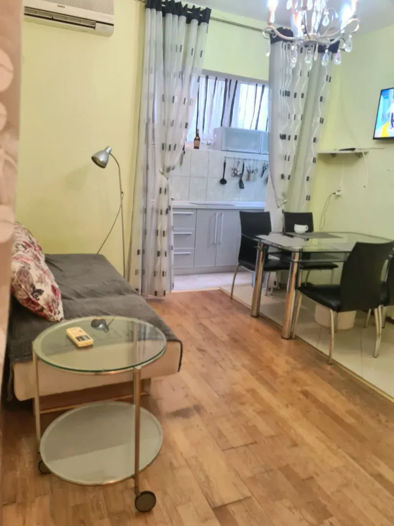 Dnevni boravak sa garniturom, trpezarijom i pogledom na kuhinju u pozadini.