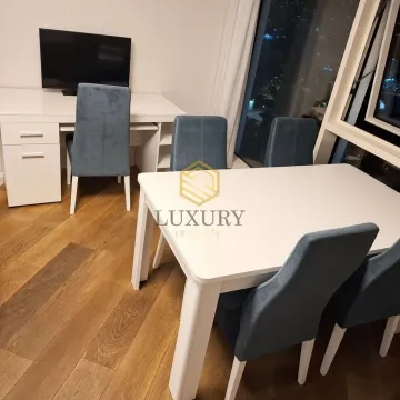 Dining area with a table and chairs and a desk with a TV in the living room. - image 10