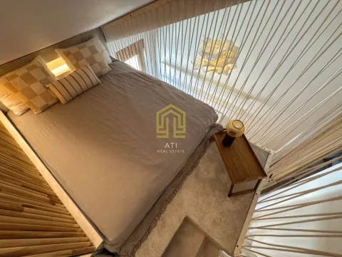 Bed with pillows and a wooden side table in an upstairs bedroom. - image 10