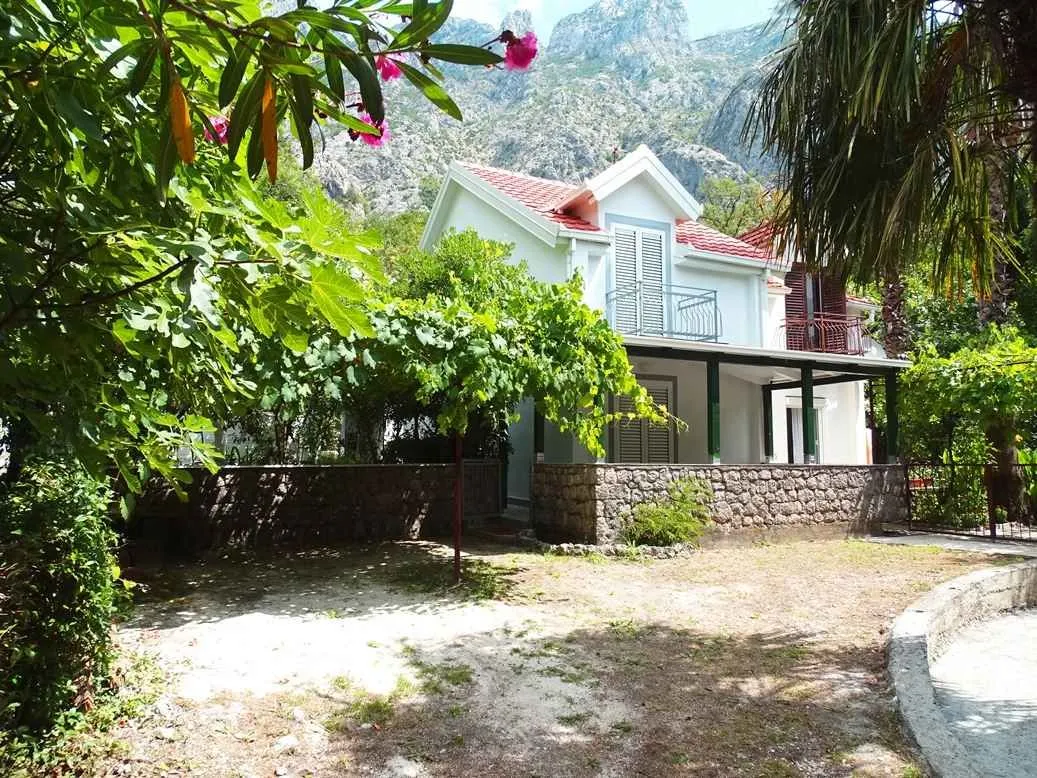 Pogled na spoljašnjost kuće sa dvoriijem i planinama u pozadini.