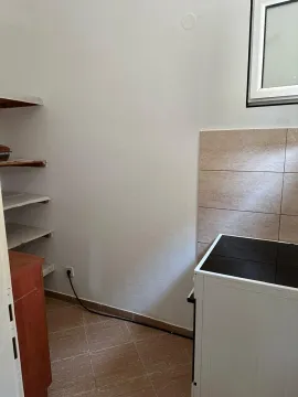 Part of the kitchen with a stove and shelves. - image 7