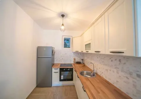 Modern kitchen with white cabinets and wooden countertops. - image 5