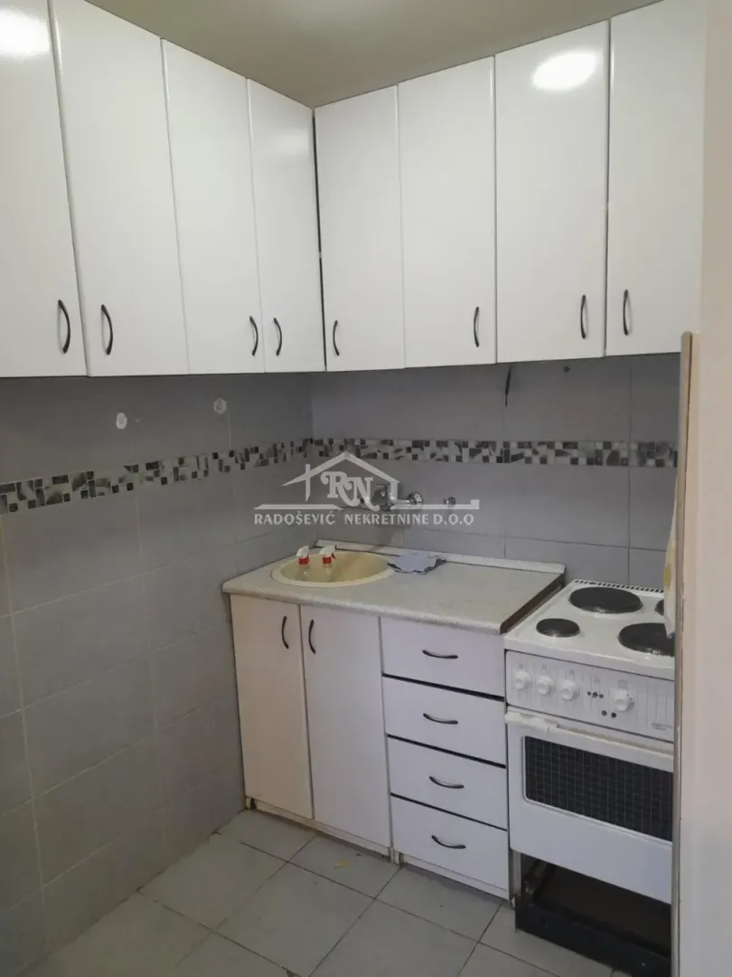 Smaller kitchen with white cabinetry and a stove.