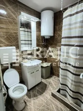 Smaller bathroom with a shower enclosure, sink, and toilet. - image 18