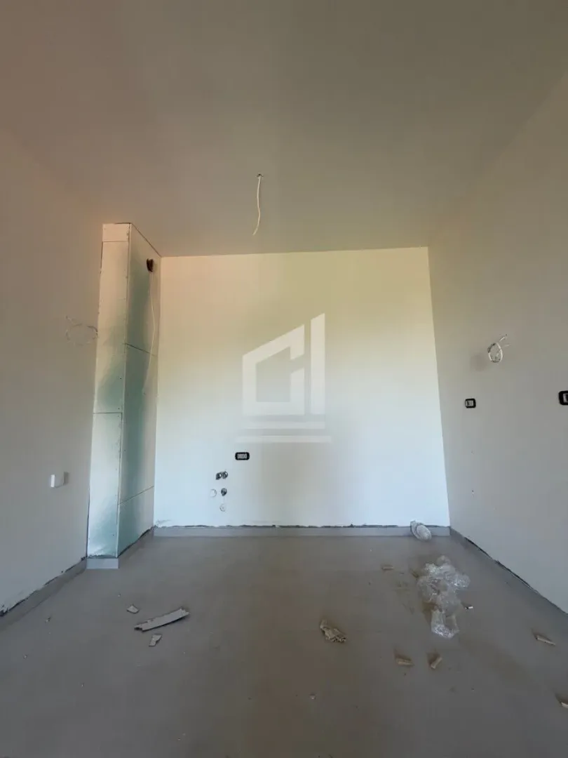 Prazna prostorija u sivoj fazi sa instalacijama na zidu.
