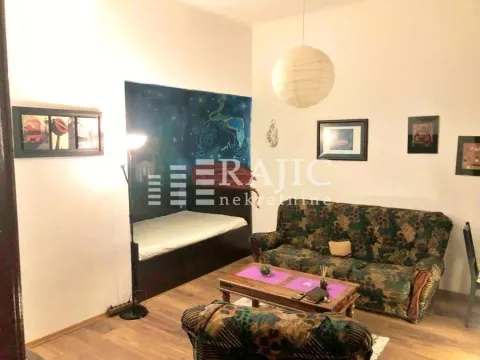 Living room with a sofa set, coffee table, and a bed in the niche. - image 8
