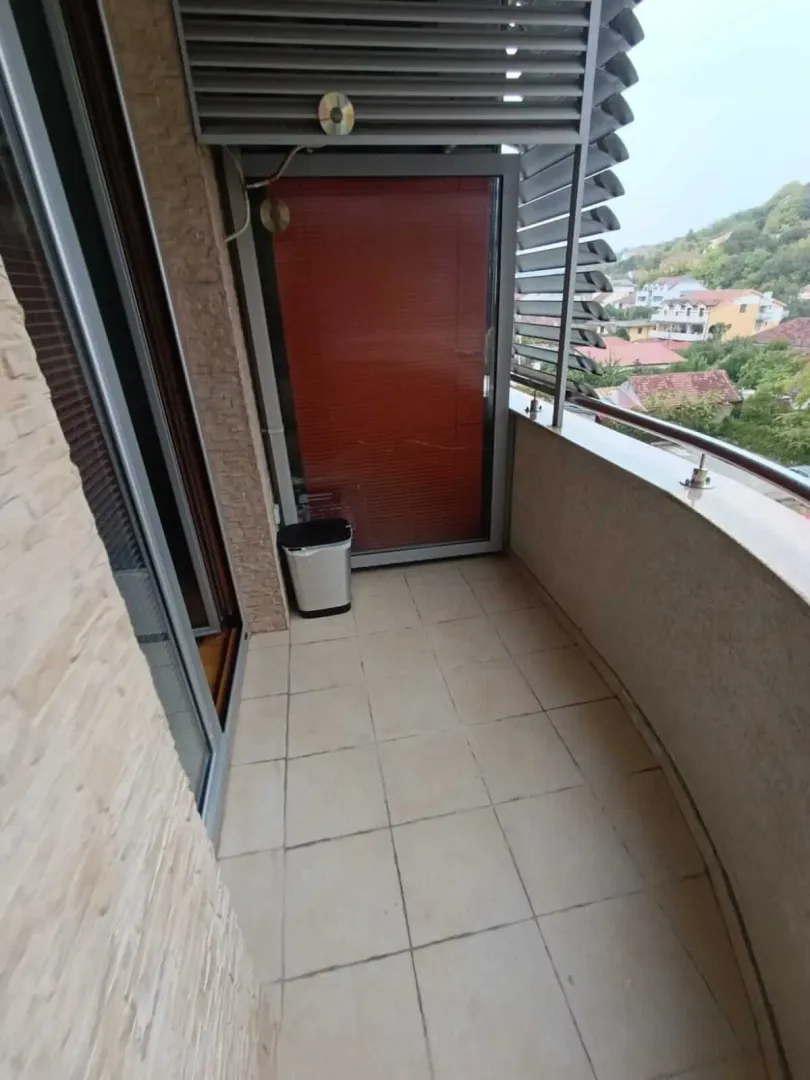 Furnished balcony with tiled flooring and a view of the surroundings.