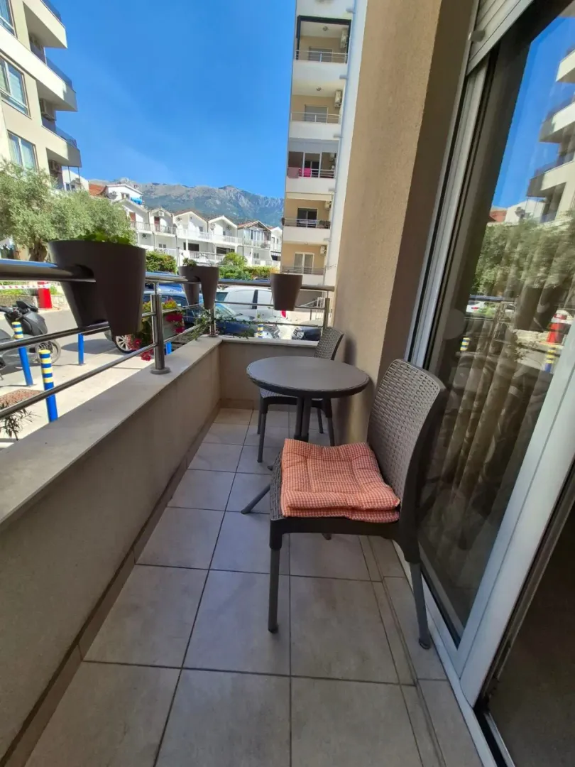 Namješten balkon sa stolom i stolicama i pogledom na okolinu.
