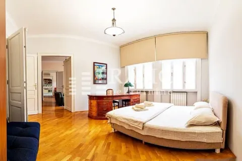 Spacious bedroom with a double bed, desk, and hardwood flooring. - image 12