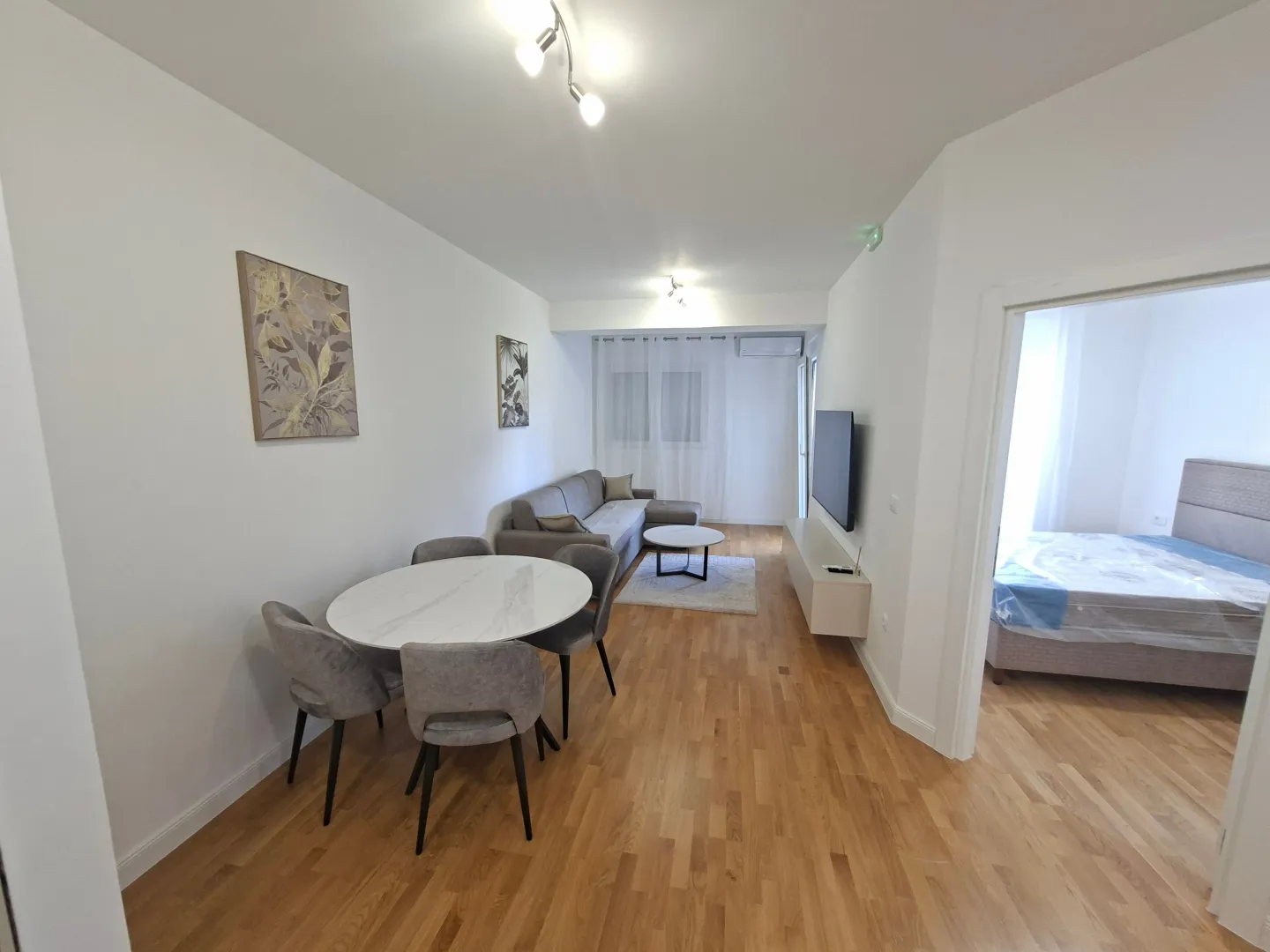 Living room with dining area and a view into the bedroom.