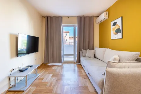Living room with a sofa, TV, and access to the terrace. - image 3