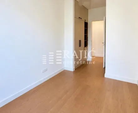 Empty room with a built-in wardrobe and wooden flooring. - image 6