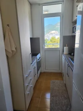 Manja kuhinja sa drvenim elementima i izlazom na terasu. - image 6