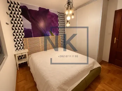 Bedroom with a double bed, built-in wardrobe, and decorative wallpaper. - image 4
