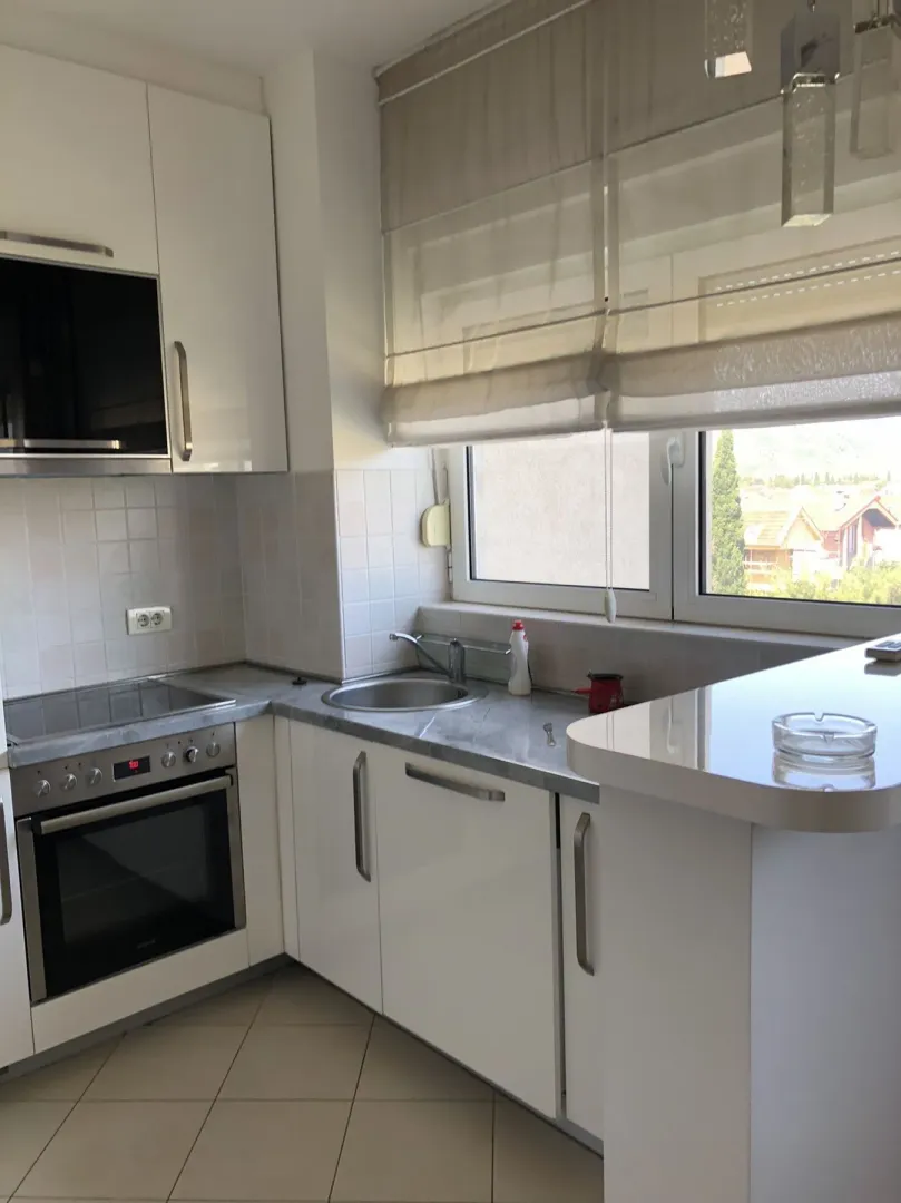 Bright kitchen featuring white cabinets and a window.