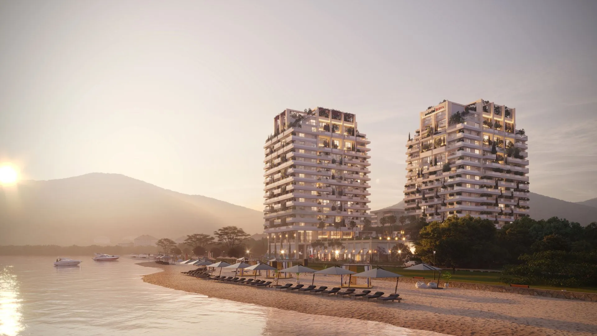 Pogled na moderne stambene zgrade i plažu u sumrak.
