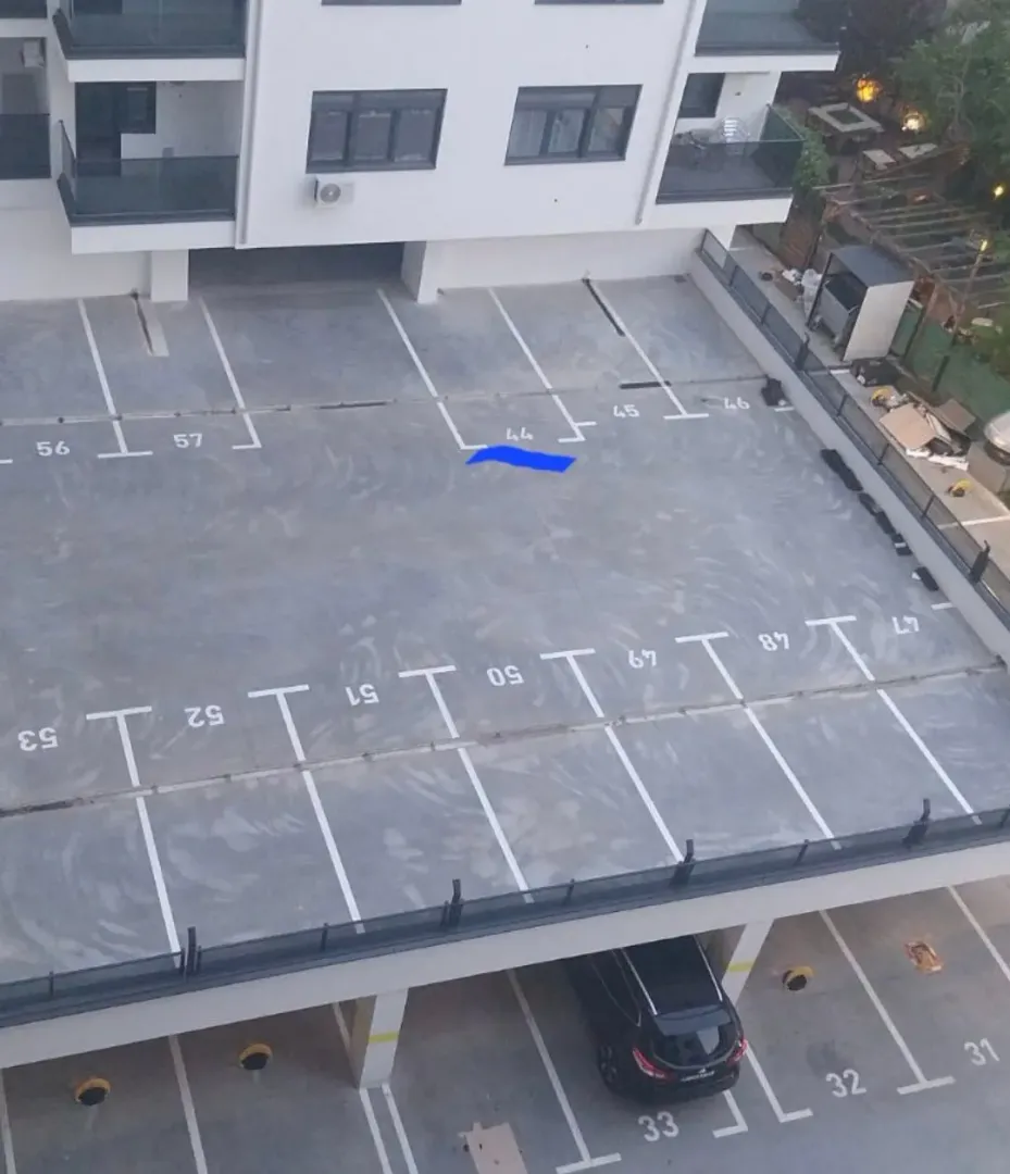 High-angle view of parking spaces in front of an apartment building.