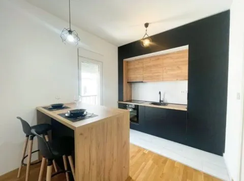 Moderna kuhinja sa drvenim elementima i šankom za ručavanje. - image 3