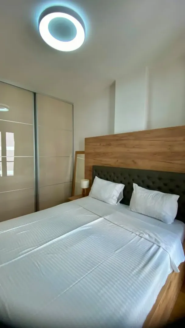Furnished bedroom with a double bed and a fitted wardrobe.