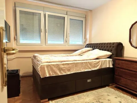 Bedroom with a double bed, windows, and a wooden chest of drawers. - image 7