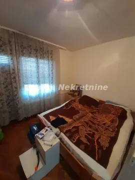 Spavaća soba sa bračnim krevetom i prozorom prekrivenim zavesama. - image 8
