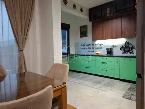 Kuhinja sa zelenim elementima i trpezarijskim stolom u produžetku. - image 5