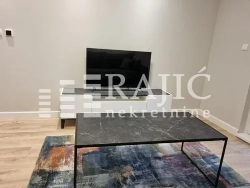 Living room with a TV, media console, and coffee table.