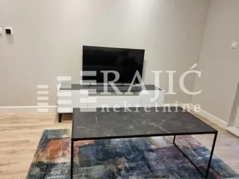 Living room with a TV, media console, and coffee table. - image 3