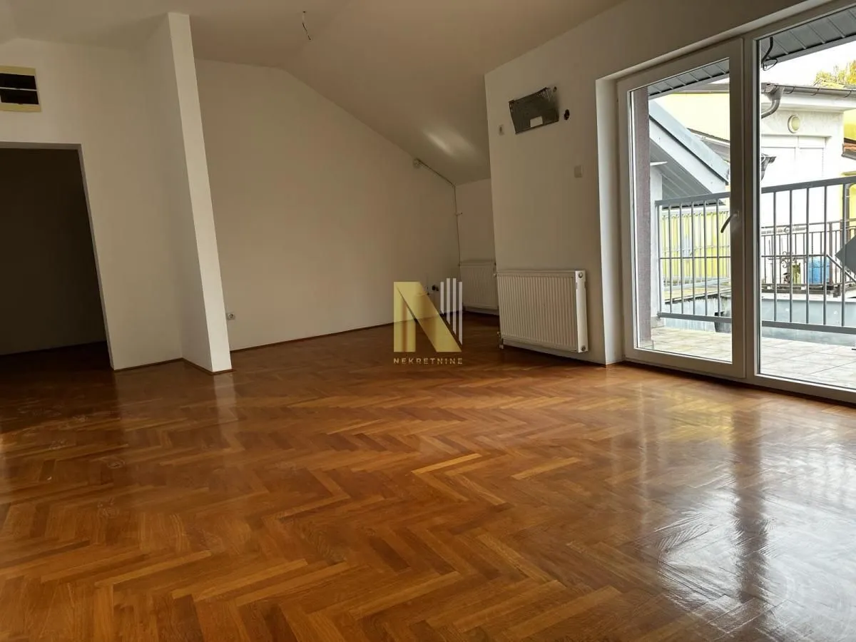 Empty room with hardwood parquet flooring and access to the terrace.
