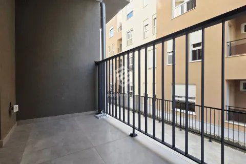 Nenamješten balkon sa metalnom ogradom i pogledom na susjednu zgradu. - image 16