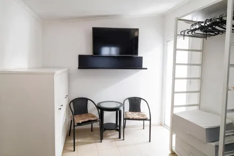 Manji svijetli dnevni boravak sa garniturom za sjedenje i televizorom na zidu. - image 13