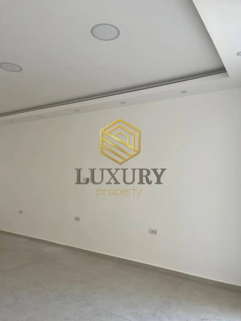 View of a white wall in an empty room with an agency logo placed on it.