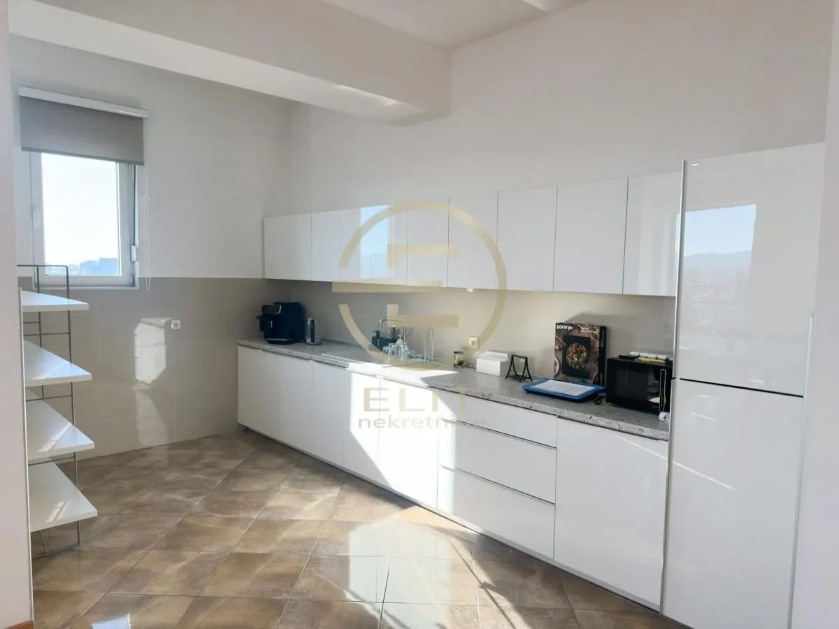 White kitchen with cabinetry and built-in appliances in the apartment.