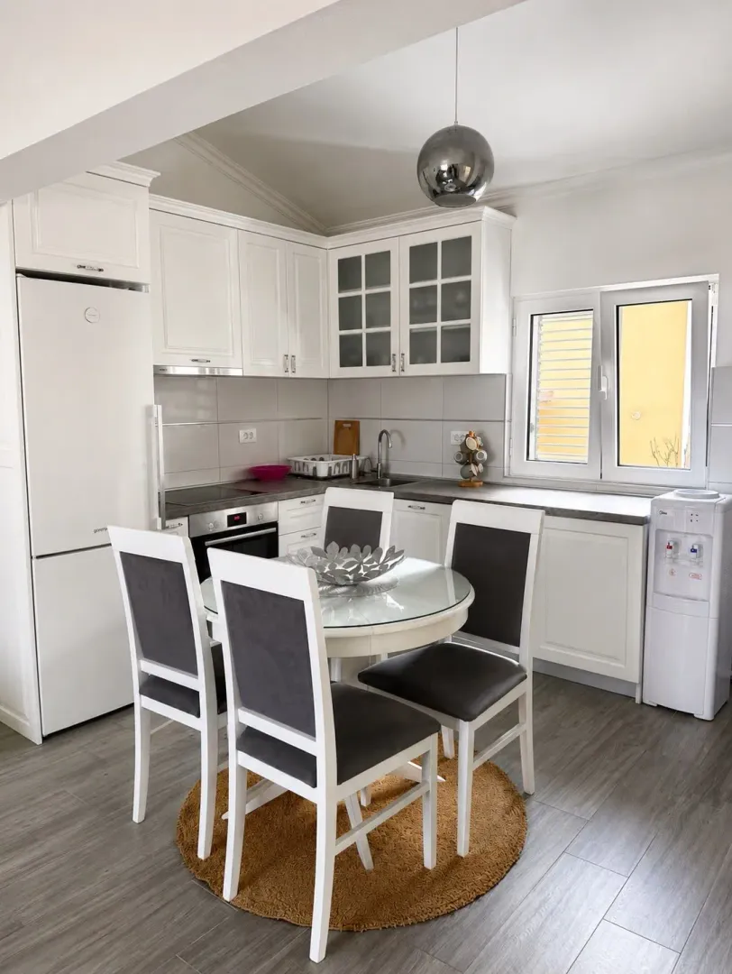 Bright kitchen with a dining table and white cabinets.
