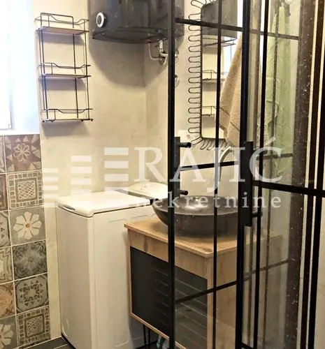 Small bathroom with a sink, washing machine, and shower cabin.