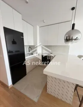 Modern kitchen with white units and a breakfast bar. - image 6