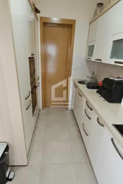 Small kitchen with white cabinets and wooden details. - image 5