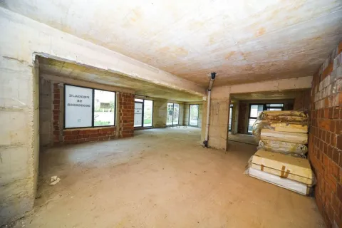 Unfinished bare space under construction with an open layout and building materials. - image 5