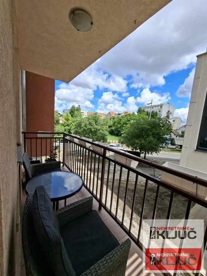 Namešten balkon sa garniturom za sedenje i pogledom na okolinu.