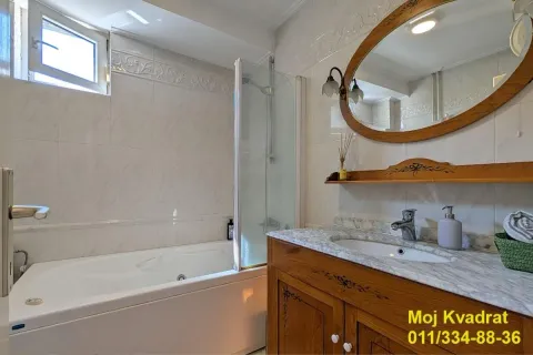 Bathroom with a bathtub, wooden vanity, and mirror. - image 9