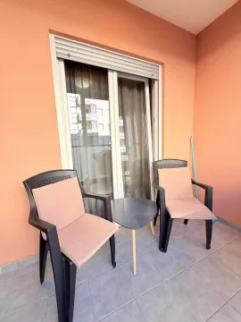 Furnished terrace with two chairs, a small table, and balcony doors. - image 10