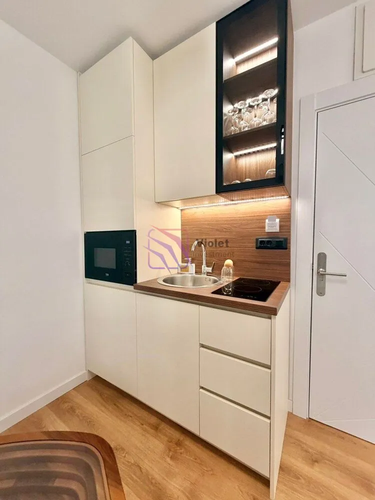 Compact kitchen with built-in cabinetry and a sink.
