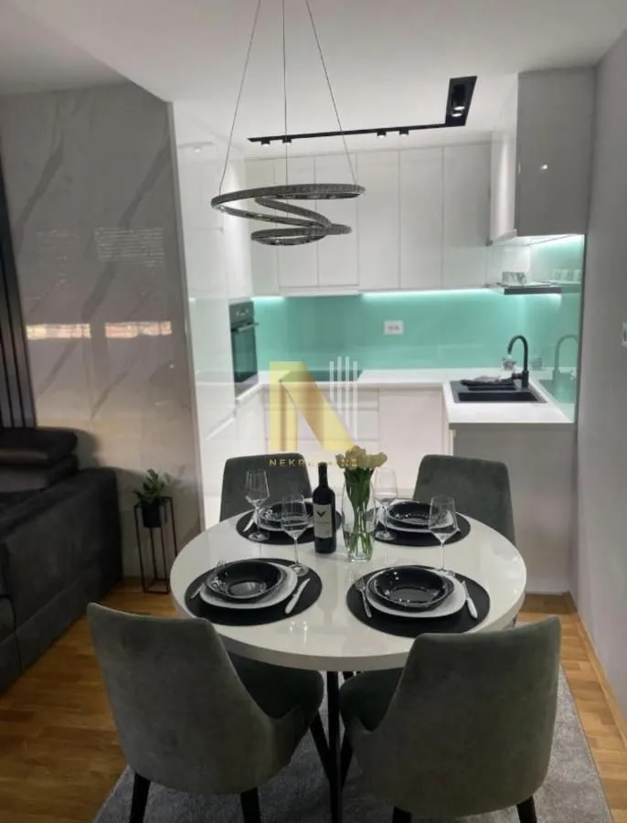 Trpezarija sa okruglim stolom i stolicama u sklopu kuhinje.