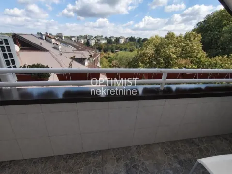 Pogled sa balkona na okolne krovove i zelenilo. - image 17